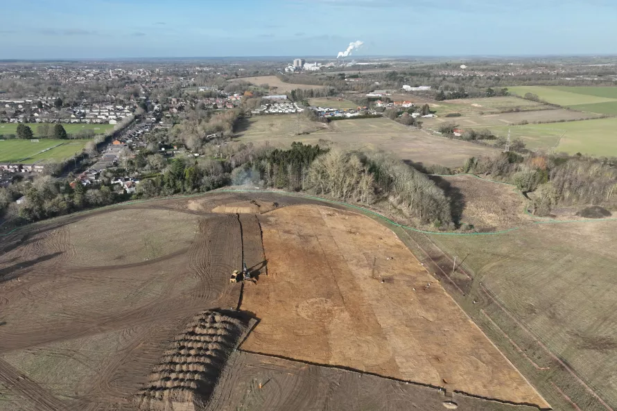 Drone view over the excavation site. In the fore ground are neat piles of spoil, as machines clear the excavation area.