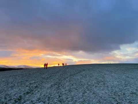 The OA team walking up a hill with sunset in the background