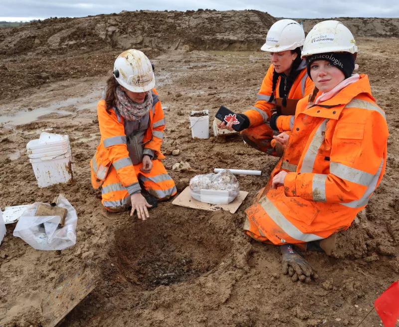 Two archaeologists getting training on how to excavate possible burial features at a Roman site.
