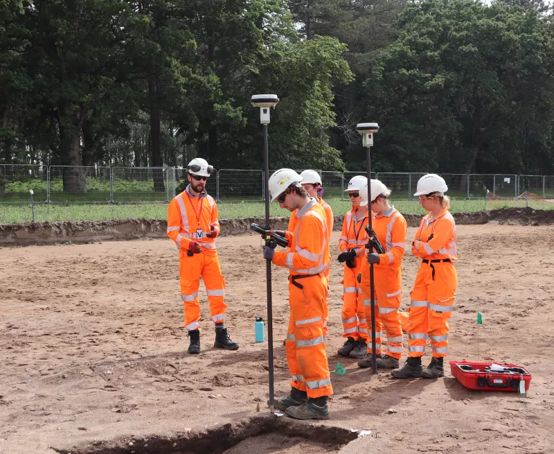 Image showing a group of OA archaeologists receiving training on using GPS to record features.